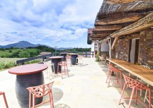 a patio with tables and chairs and a building at Appartement vue montagnes - MENDIBIL in Zugarramurdi