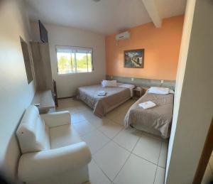 a living room with two beds and a couch at Pousada Fuzer in Restinga Sêca