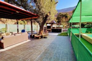 un patio esterno con un tetto verde e un albero di Renovated Tiny House a San Bartolomé