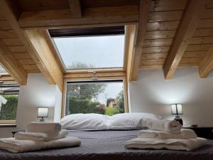 ein Schlafzimmer mit zwei Handtüchern auf einem Bett mit einem großen Fenster in der Unterkunft Comfort Room 4 Dogana Svizzera in San Fermo della Battaglia