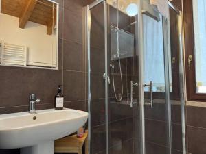 ein Bad mit einem Waschbecken und einer Glasdusche in der Unterkunft Comfort Room 4 Dogana Svizzera in San Fermo della Battaglia