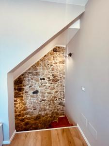 a staircase with a stone wall in a house at CRYSAS HOME in Assoro