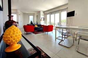 ein Wohnzimmer mit einem Tisch und roten Stühlen in der Unterkunft Villa Orizzonte sullo Jonio in Avola
