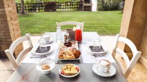 una mesa con una bandeja de comida y café. en Bio Agriturismo Poggio Aione en Saturnia