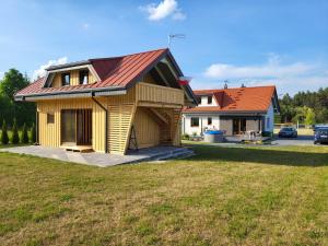 ein kleines Haus mit rotem Dach auf einem Hof in der Unterkunft Domki u Stefana in Józefów
