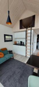 uma sala de estar com um sofá azul e uma cozinha em De Kapschuur em Stadskanaal