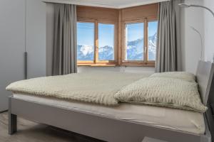a bedroom with a bed with a view of mountains at Ferienwohnungen Zurschmitten in Riederalp