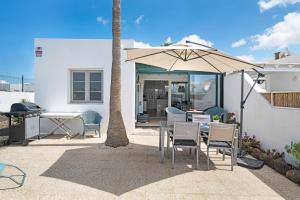 une terrasse avec une table et un parasol dans l'établissement Mi Casita, à Playa Blanca