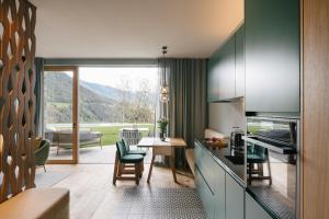 a kitchen with a view of a living room at ANTON Nature Hideaway in Natz-Schabs
