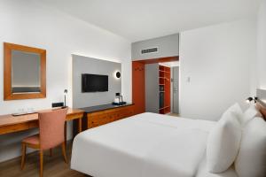 Dormitorio con cama, escritorio y TV en Danubius Hotel Hungaria City Center, en Budapest