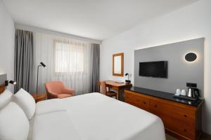 Habitación de hotel con cama y TV de pantalla plana. en Danubius Hotel Hungaria City Center en Budapest