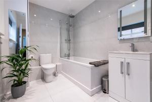 uma casa de banho com uma banheira, um WC e um lavatório. em Blackfriars House, overlooking Chester Racecourse em Chester
