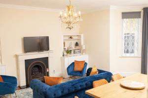 a living room with blue furniture and a fireplace at Stunning 3BR Apt Retreat on River Thames l 5Bd2Bth in London
