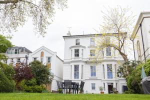 a white house with black chairs in front of it at Stunning 3BR Apt Retreat on River Thames l 5Bd2Bth in London