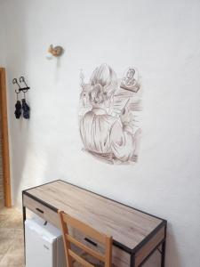 Un disegno di una donna che tiene un bambino su un muro di Beni Benìus a Teulada
