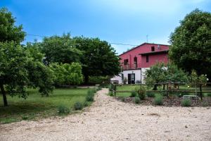 a garden in front of a pink house at Villa Magda in Todi