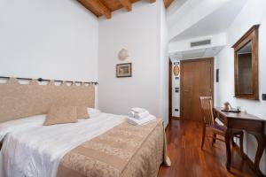 sypialnia z łóżkiem, biurkiem i stołem w obiekcie Locanda Da Vittorio w Manerba del Garda