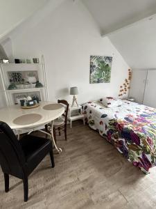 a bedroom with a bed and a table and a table at Le cocon jaune - Studio en hyper centre in Lamballe