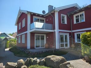 a red house with rocks in front of it at STRANDNAH STRANDLÖWE KÜHLUNGSBORN Ostsee in Kühlungsborn