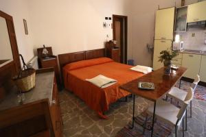 a bedroom with a bed and a table and a kitchen at La Casa Dei Cestai in Linguaglossa