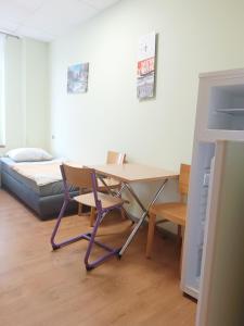 einen Schreibtisch mit Stuhl und ein Bett in einem Zimmer in der Unterkunft Hostel Krośnieńska 12 in Zielona Góra