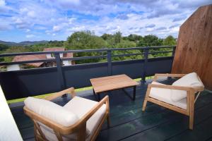 a patio with two chairs and a table on a balcony at Appartement vue montagnes- IBANTELI in Zugarramurdi +2 photos
