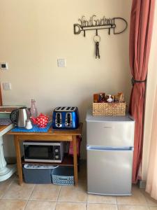 een keuken met een koelkast en een tafel met een magnetron bij Myrtleberry Studio in Castlemorton