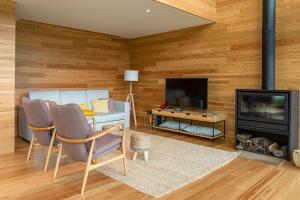 uma sala de estar com paredes de madeira e uma lareira em Sete Cidades Lake Cabin - Casa da Lagoa em Ponta Delgada