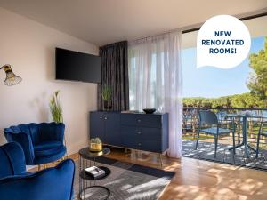a living room with a blue furniture and a balcony at Falkensteiner Hotel Adriana - Adults Only in Zadar