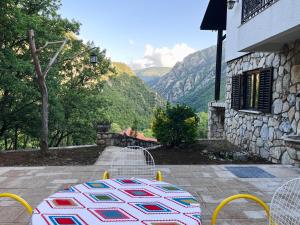uma mesa com um cobertor num pátio com montanhas em Canyon View Lodge - Matka em Matka