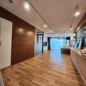 ein Büro mit einem Flur mit Holzböden und einer großen Wand in der Unterkunft Ariene Guesthouse in Gwangju