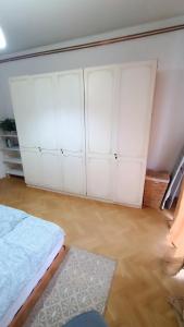 a bedroom with white cabinets and a wooden floor at Moon Tree *** in Varaždin