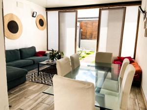 ein Wohnzimmer mit einem Glastisch und Stühlen in der Unterkunft Agüita Surf Lodge in Las Palmas de Gran Canaria