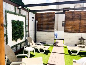 a patio with chairs and a plant on the wall at Agüita Surf Lodge in Las Palmas de Gran Canaria