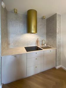 a kitchen with white cabinets and a sink at KOBIELA APARTMENTS Dębowe Tarasy in Katowice