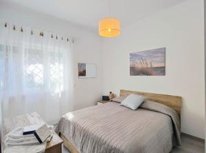 una camera da letto bianca con un letto e una finestra di Bell'Aria Nettuno a Nettuno