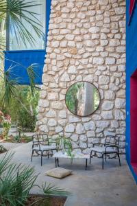 zwei Bänke neben einer Steinmauer mit einem Fenster in der Unterkunft El botanico de Sagra in Sagra
