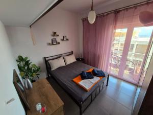 a bedroom with a bed and a table and a window at Beach apartment in Paleo Tsifliki