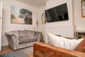 a living room with a couch and a tv at Cosy Countryside Hideout - Pass the Keys in Whisby