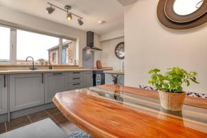 a kitchen with a wooden table and a potted plant at Cosy Countryside Hideout - Pass the Keys in Whisby