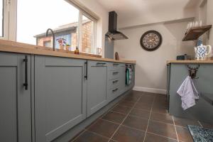 a kitchen with white cabinets and a counter at Cosy Countryside Hideout - Pass the Keys in Whisby +33 photos