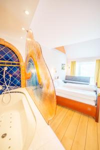 Habitación con baño con cama y bañera. en Bavaria Lifestyle Hotel, en Altötting