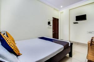 SPOT ON Sri Surya Lodge tesisinde bir odada yatak veya yataklar