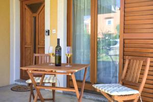 una mesa con dos botellas y dos copas de vino en Apartman Meri en Krk