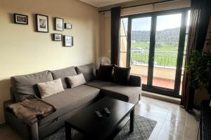 a living room with a couch and a large window at Costa SPA Ático de lujo - Playa de las Catedrales in San Miguel de Reinante