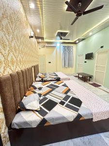 fila de camas en una habitación con ventilador de techo en TEMPLE TOWN HOMES assi ghat Varanasi en Varanasi