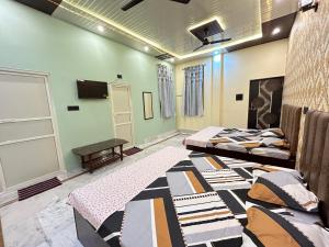Zimmer mit 2 Betten und einem Tisch in der Unterkunft TEMPLE TOWN HOMES assi ghat Varanasi in Varanasi