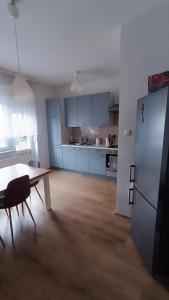 a kitchen with blue cabinets and a table and a refrigerator at Moon Tree *** in Varaždin