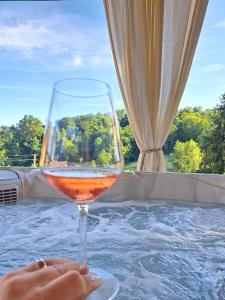 un bicchiere di vino seduto sopra un tavolo di Villa Magnolia a Sveti Martin na Muri