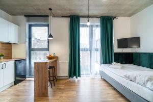Schlafzimmer mit einem großen Bett und grünen Vorhängen in der Unterkunft Apartamenty Silver Place in Stettin